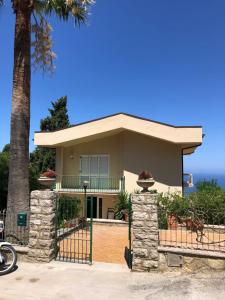 a house with a gate and a palm tree at Villa Panoramica in Valderice