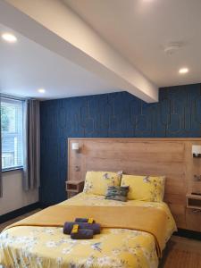 a bedroom with a bed and a blue wall at Roe Valley Apartments in Limavady