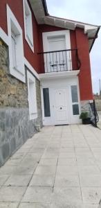 un edificio con puerta blanca y balcón en Casa La Ranera de Santillana en Santillana del Mar