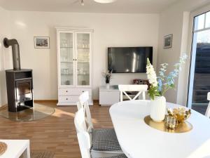 a living room with a white table and a fireplace at Haus Eversand Nr 1 in Cuxhaven