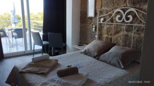 1 dormitorio con 1 cama con pared de piedra en Vilar Norte, en Bueu