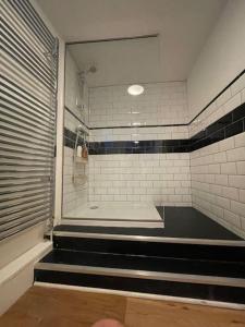 a bathroom with a shower with black and white tiles at Sunset views Margate main sands in Kent