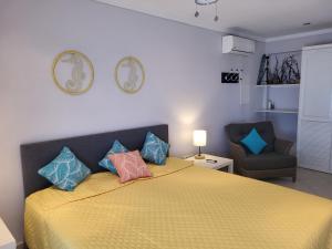 a bedroom with a yellow bed with pillows on it at Den Laman - Balloonfish in Kralendijk