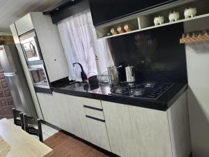 Il comprend une cuisine équipée d'une cuisinière et d'un réfrigérateur. dans l'établissement Casa Justi Oliveira, à Lauro Müller