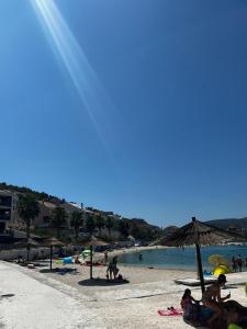 eine Gruppe von Menschen, die mit einem Sonnenschirm am Strand sitzen in der Unterkunft A&M Apartment in Marina