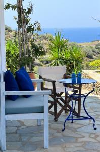 un patio con tavolo, sedia, tavolo e tavolo di Gorgeous private Villa with sea view! ad Andro