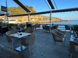 ホラ・スファキオンにあるHotel Alkyonのテーブルと椅子が備わるレストランで、水辺の景色を望めます。