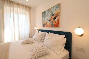 a bedroom with a bed with white sheets and pillows at Apartment Summer Cave in Poreč center in Poreč