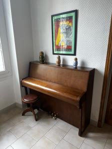 un piano en una habitación con una foto en la pared en Appartement 4 à 8 personnes, Spacieux de Standing en Nimes