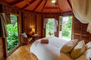 a bedroom with a large bed in a room with windows at Hamakua Sanctuary in Honokaa