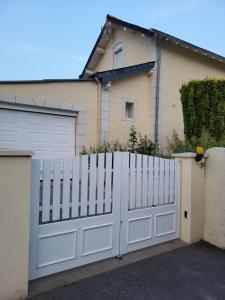 una cerca blanca frente a una casa en L'escale des roses en Doué-la-Fontaine