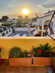 a balcony with twootted plants and a swimming pool at SANT MORI GRAN TERRASSA in Empuriabrava
