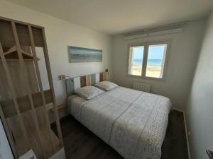 a bedroom with a bed and a window at Vue mer exceptionnelle à Cabourg in Cabourg