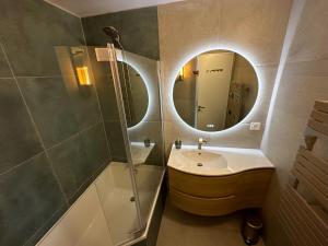 y baño con lavabo, ducha y espejo. en Vue mer exceptionnelle à Cabourg, en Cabourg