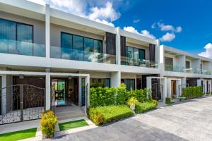 Una vista exterior de una casa con entrada para vehículos. en New Luxury Two bedroom private swimming pool villa with complete supporting facilities, convenient for travel 800 meters to Kamala Beach H09, en Kamala Beach