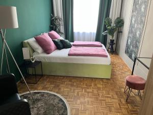 a room with a bed with pink pillows on it at Apartment Vienna Niko in Vienna