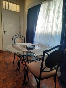a table and chairs in a room with a window at Delight homestay shared apartment in Nairobi