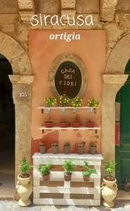 a sign for a flower shop with potted plants at Casa dei fiori in Siracusa