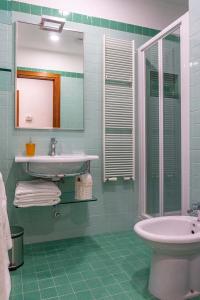 La salle de bains est pourvue d'un lavabo, d'un miroir et d'une baignoire. dans l'établissement Karisma Suites, à Rome