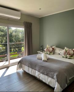 a bedroom with a large bed and a large window at Serene Place Guest House & Conference Venue AFFORDABLE LUXURY WITH BACKUP POWER in Roodepoort