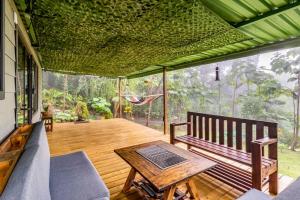 a screened in porch with a bench and a table at Tiny house Monteverde in Monteverde Costa Rica