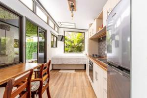 eine Küche mit einem Tisch und Stühlen sowie ein Schlafzimmer in der Unterkunft Tiny house Monteverde in Monteverde Costa Rica