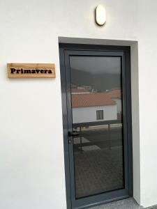 una puerta negra con un cartel en una pared blanca en Apartamentos 4 estações, en Faja Grande