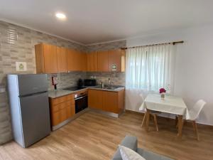 a small kitchen with a table and a refrigerator at Apartamentos 4 estações in Faja Grande