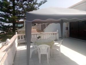 a table and chairs under an umbrella on a patio at Villa Keltoum in Moulay Bousselham