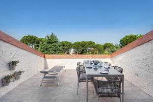 a patio with a table and chairs on a brick wall at Luxury Penthouse/Pool/50m to lake in Bardolino