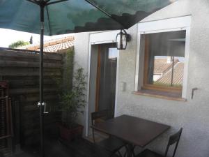 einen Tisch mit einem Regenschirm neben einem Fenster in der Unterkunft La Parenthèse in Sommières