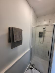 ein Bad mit einer Dusche, einem WC und einem Handtuch in der Unterkunft Dawson House in Darlington