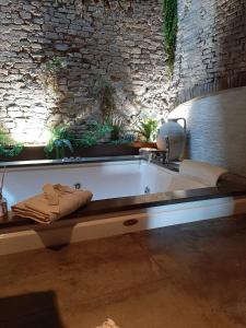 Cette chambre dispose d'une baignoire et d'un mur en pierre. dans l'établissement BORGO DI BEPPE E GLORIA SUITE, à San Giovanni Valdarno