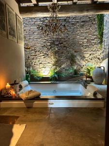 a bath tub in a room with a stone wall at BORGO DI BEPPE E GLORIA SUITE in San Giovanni Valdarno