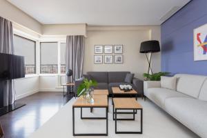 a living room with a couch and a tv at Impresionante apartamento en edificio de lujo SELTON PLAZA ESPAÑA in Madrid
