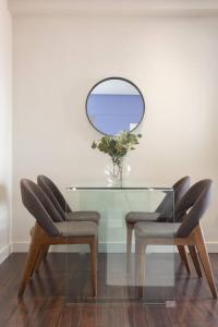 a glass table with two chairs and a mirror at Impresionante apartamento en edificio de lujo SELTON PLAZA ESPAÑA in Madrid