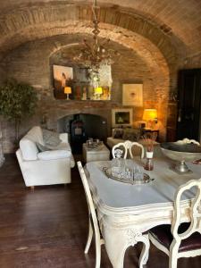 - un salon avec une table, des chaises et un canapé dans l'établissement BORGO DI BEPPE E GLORIA SUITE, à San Giovanni Valdarno