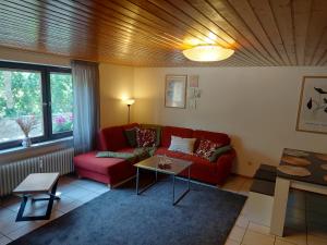 - un salon avec un canapé rouge et une table dans l'établissement Ferienwohnung am Bächle, à Münstertal