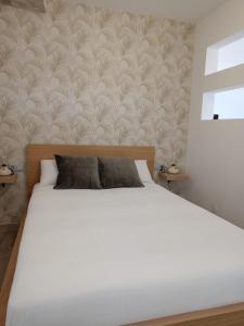 a bedroom with a white bed with a wall at La Lunita in Valverde