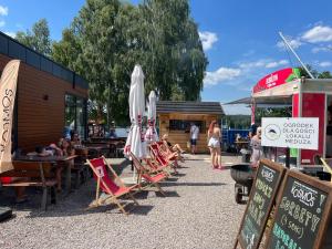 un gruppo di sedie e ombrelloni in un ristorante di Family & Business Sauna Apartments No3 Leśny nad Zalewem Cedzyna - 2 Bedroom with Private Sauna, Bath with Hydromassage, Terrace, Parking, Catering Options a Kielce