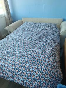 a bed with a blue comforter on top of it at Chalet 281 Golden Sands Holiday Park in Withernsea