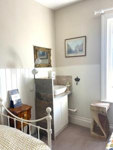 1 dormitorio con lavabo y baño con cama en La Di Da Hotel beach town en Bournemouth