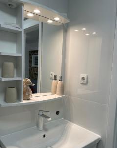uma casa de banho branca com um lavatório e um espelho em Apartment GAVIOTA Krk em Krk