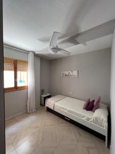 een slaapkamer met een bed en een plafondventilator bij Apartamento frente al mar en El Campello in El Campello