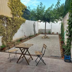 a picnic table and two chairs in a courtyard at La Llacuna in Vila-Sana