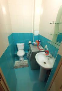 a blue bathroom with a toilet and a sink at Stylish apartment in the city center in Bishkek +11 photos