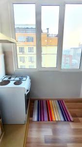 a kitchen with a stove and two windows at Stylish apartment in the city center in Bishkek