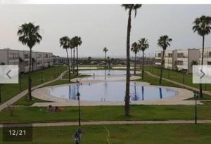 ein großer Pool mit Palmen in einem Park in der Unterkunft Ola Blanca 2 Sidi Rahal in Zemmour Touirza