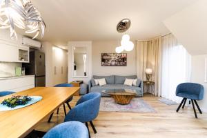 a living room with a couch and a table and chairs at VacationClub – Ogrody Pieniawskie Apartament 44 in Polanica-Zdrój