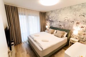 a bedroom with a bed with a floral wall at VacationClub – Ogrody Pieniawskie Apartament 44 in Polanica-Zdrój